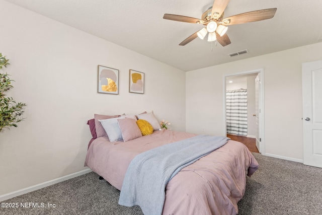 carpeted bedroom featuring baseboards, connected bathroom, and ceiling fan