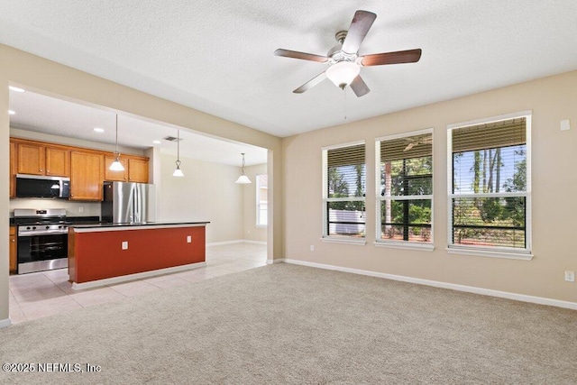 680 Briar View Dr, Orange Park, FL 32065 - kitchen featuring appliances with stainless steel finishes, a center island, ceiling fan, baseboards, and brown cabinetry