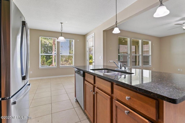 680 Briar View Dr, Orange Park, FL 32065 - kitchen featuring appliances with stainless steel finishes, a sink, ceiling fan, brown cabinetry, and light tile patterned floors