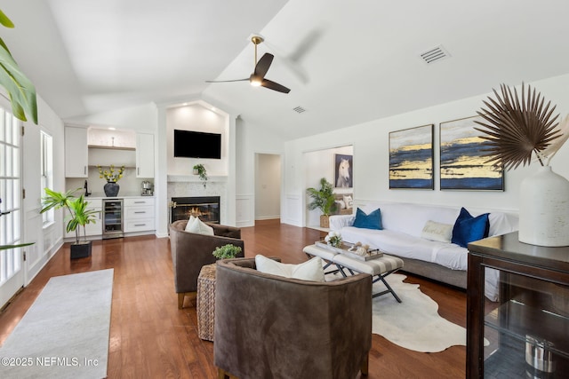 1553 Royal Fern Ln, Fleming Island, FL 32003 - living room with wine cooler, ceiling fan, vaulted ceiling, a tiled fireplace, and dark wood finished floors