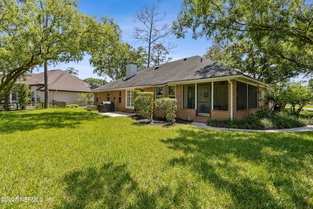 1553 Royal Fern Ln, Fleming Island, FL 32003 - rear view of house featuring brick siding, a sunroom, a chimney, a patio area, and a shingled roof