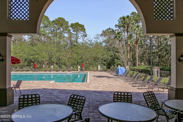 1553 Royal Fern Ln, Fleming Island, FL 32003 - community pool featuring a patio, view of wooded area, and outdoor dining area