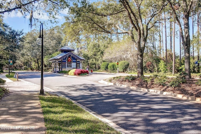 1553 Royal Fern Ln, Fleming Island, FL 32003 - view of asphalt road with curbs, street lights, traffic signs, sidewalks, and view of scattered trees