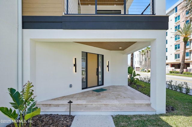 doorway to property featuring stucco siding