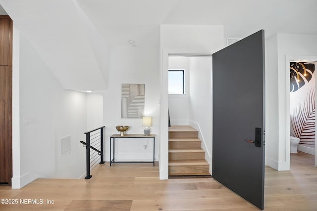 staircase with wood finished floors and baseboards