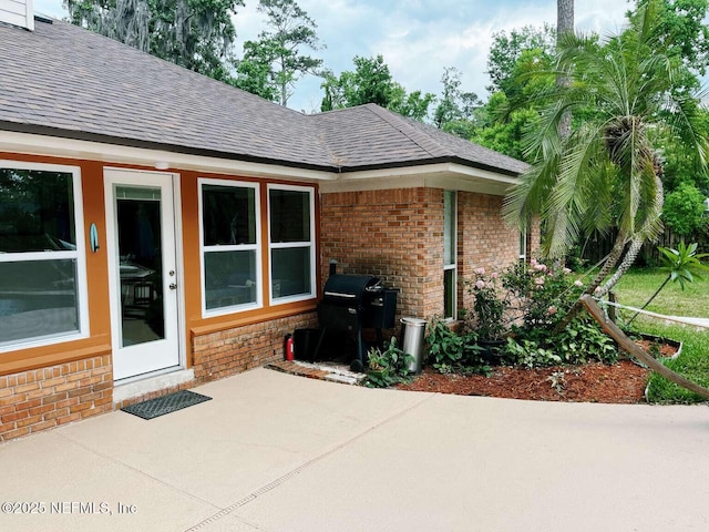 1734 Alps Ct, Fleming Island, FL 32003 - doorway to property featuring brick siding, a patio area, and a shingled roof