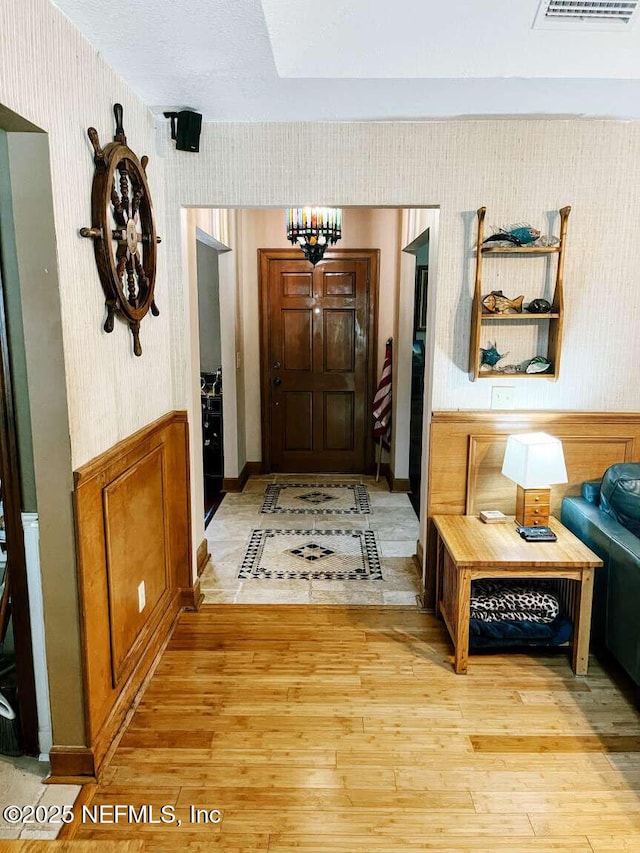1734 Alps Ct, Fleming Island, FL 32003 - hall with wallpapered walls, light wood-style floors, and a wainscoted wall