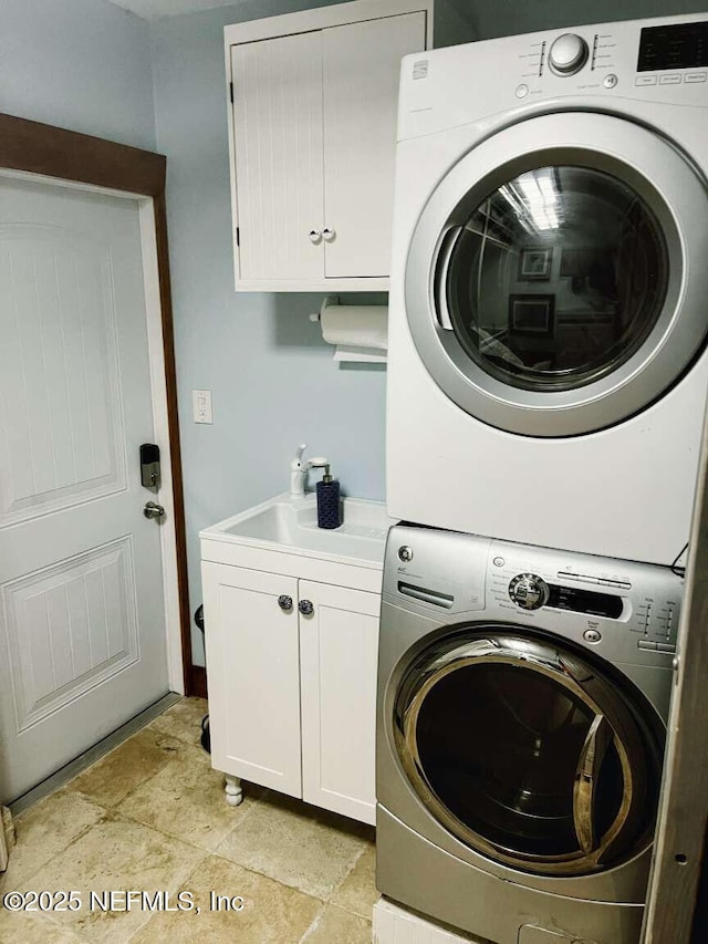 1734 Alps Ct, Fleming Island, FL 32003 - washroom with stacked washing machine and dryer, cabinet space, and light stone finish floors