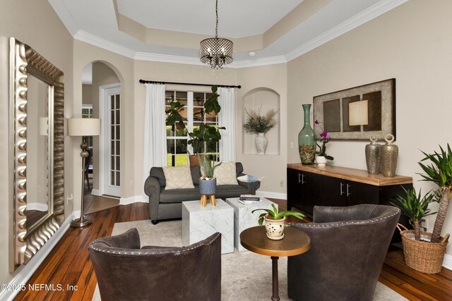 3854 Painted Bunting Way, Jacksonville, FL 32224 - living room with a tray ceiling, arched walkways, hardwood / wood-style flooring, baseboards, and crown molding
