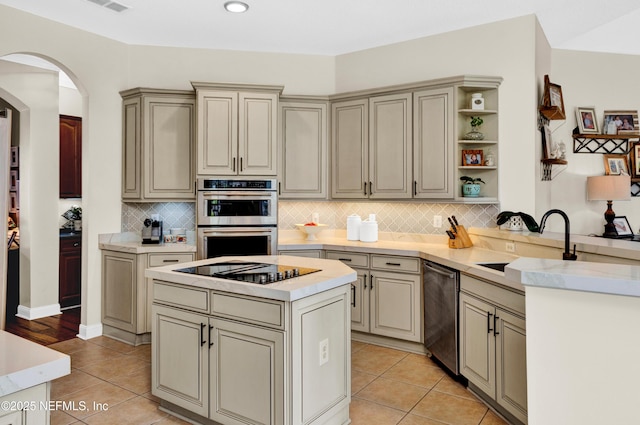 3854 Painted Bunting Way, Jacksonville, FL 32224 - kitchen featuring appliances with stainless steel finishes, a sink, arched walkways, light countertops, and decorative backsplash