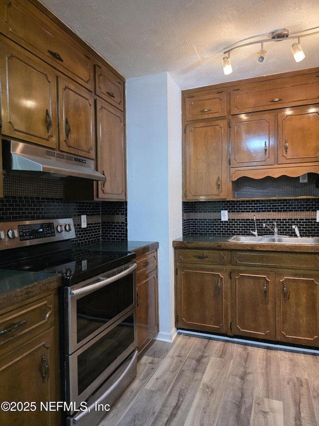 54038 Charles St, Callahan, FL 32011 - kitchen featuring stainless steel range with electric cooktop, under cabinet range hood, dark countertops, backsplash, and a textured ceiling