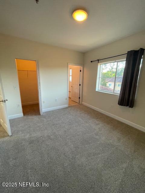 9745 Touchton Rd Unit 2522, Jacksonville, FL 32246 - unfurnished bedroom featuring baseboards, carpet flooring, and a spacious closet