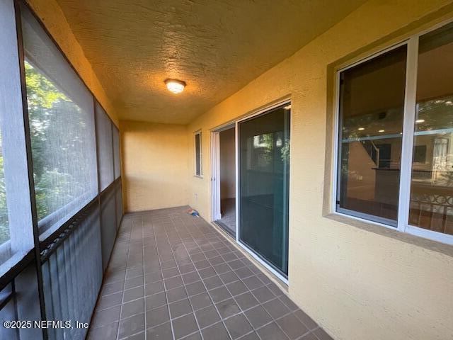 9745 Touchton Rd Unit 2522, Jacksonville, FL 32246 - unfurnished sunroom with a textured ceiling and tile patterned floors