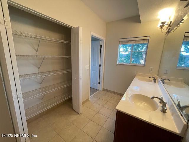 9745 Touchton Rd Unit 2522, Jacksonville, FL 32246 - bathroom featuring healthy amount of natural light, tile patterned flooring, double vanity, and a spacious closet