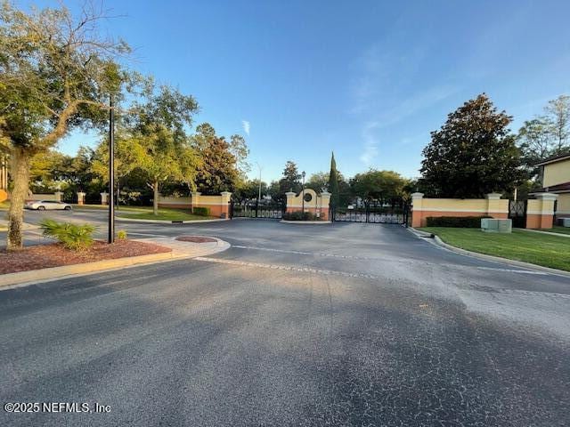 9745 Touchton Rd Unit 2522, Jacksonville, FL 32246 - view of asphalt street with curbs, a gate, and a gated entry