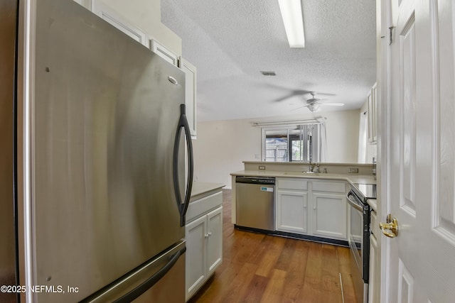 726 Calico Jack Way, Green Cove Springs, FL 32043 - kitchen with appliances with stainless steel finishes, a textured ceiling, dark wood-style floors, light countertops, and a ceiling fan