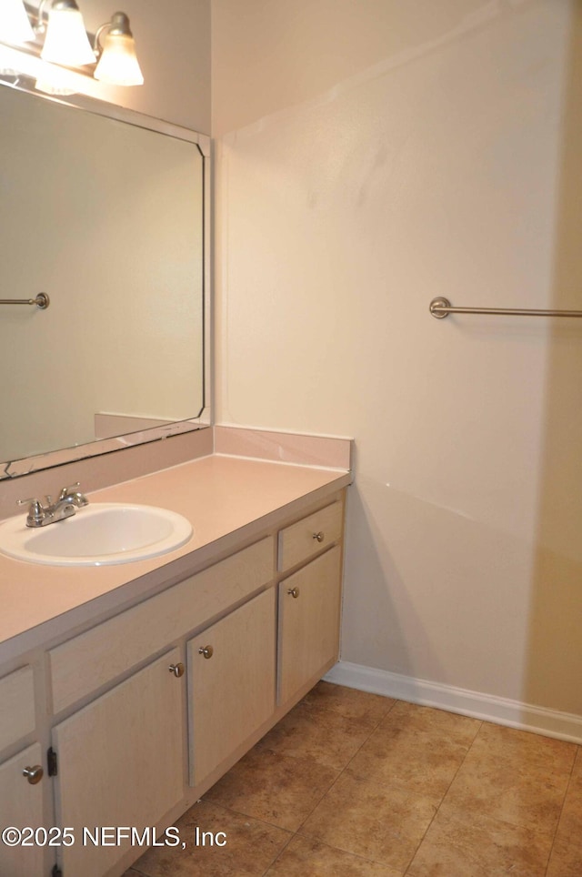 bathroom featuring vanity, baseboards, and tile patterned flooring