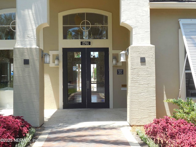 doorway to property featuring french doors and stucco siding