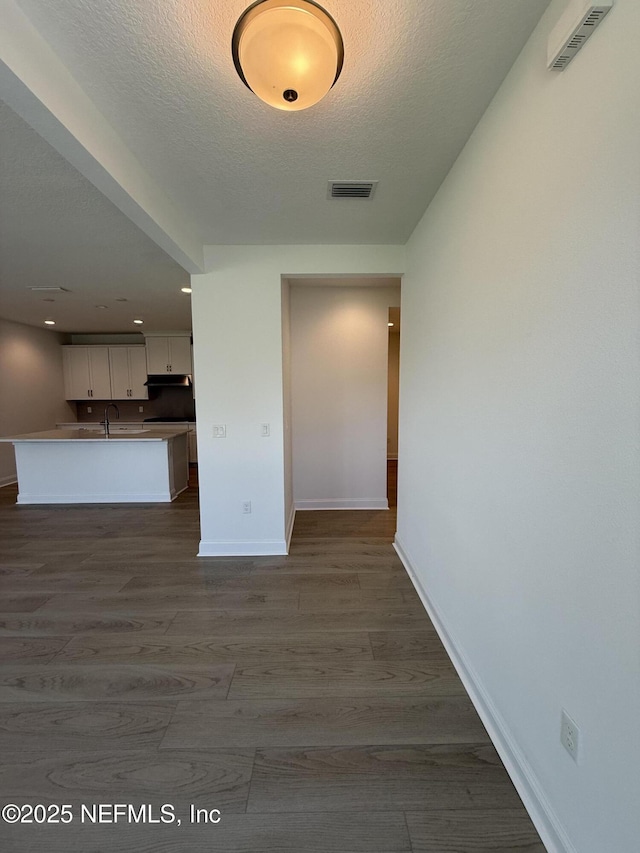 38 Mulberry Rd, Palm Coast, FL 32164 - unfurnished living room with a sink, baseboards, a textured ceiling, dark wood-style floors, and recessed lighting