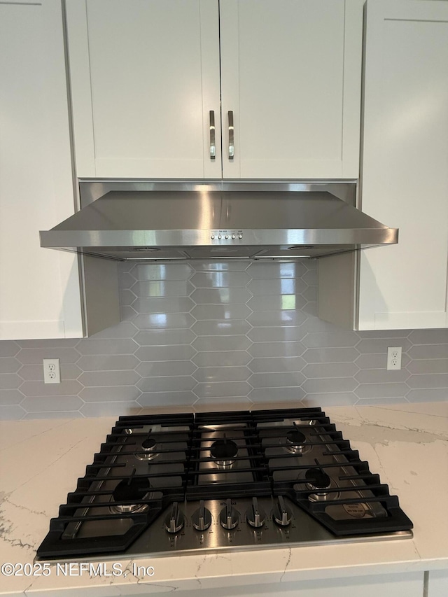 38 Mulberry Rd, Palm Coast, FL 32164 - kitchen view of stainless steel gas stovetop, decorative backsplash, and white cabinetry