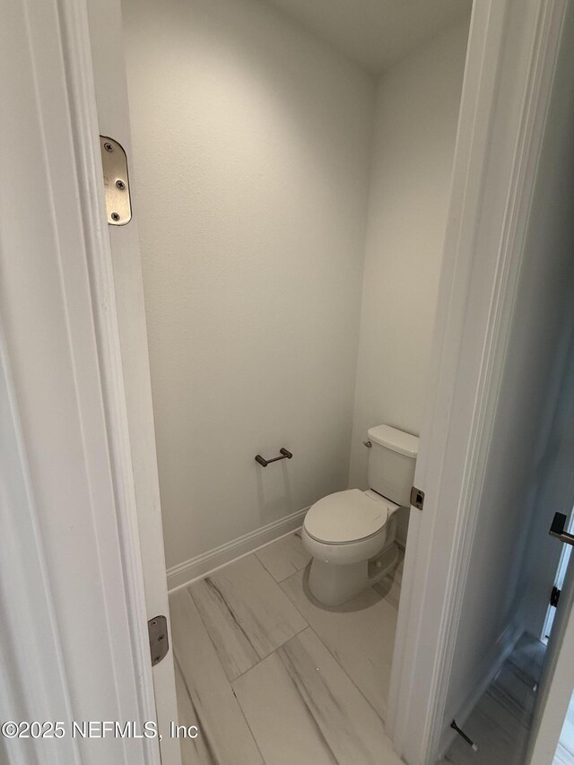38 Mulberry Rd, Palm Coast, FL 32164 - bathroom featuring toilet and marble look tiles