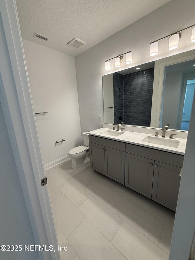 38 Mulberry Rd, Palm Coast, FL 32164 - full bathroom with a textured ceiling, double vanity, toilet, and baseboards