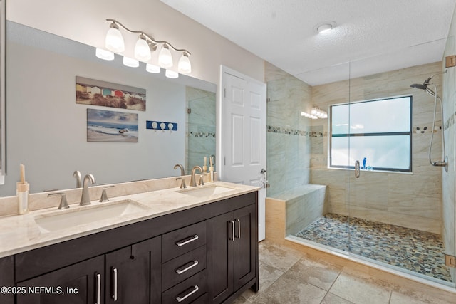 full bathroom with a stall shower, a textured ceiling, and double vanity
