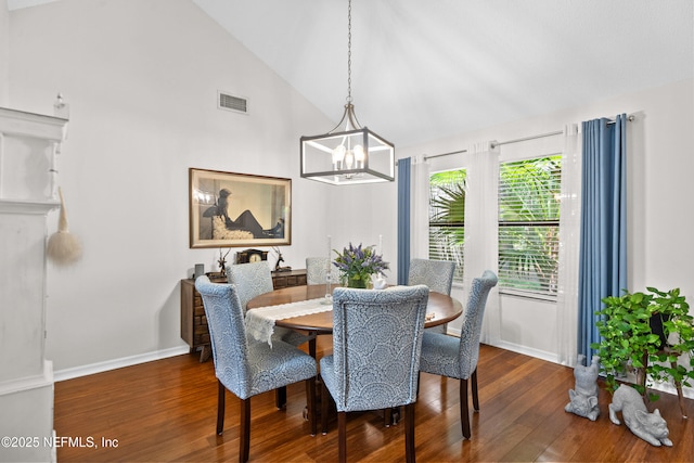 dining area featuring wood finished floors, a chandelier, high vaulted ceiling, and baseboards