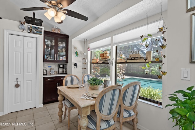 dining area with light tile patterned floors, a ceiling fan, and baseboards
