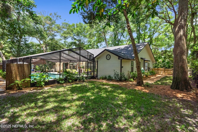 back of house featuring an outdoor pool and glass enclosure