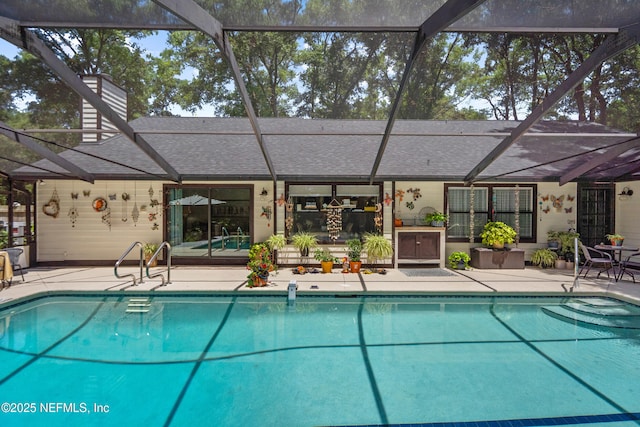 outdoor pool featuring a patio area and glass enclosure