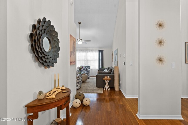 corridor with wood finished floors and baseboards