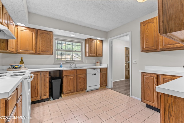 347 Greencastle Rd Unit 46, Jacksonville, FL 32225 - kitchen featuring white appliances, light countertops, brown cabinets, under cabinet range hood, and a textured ceiling