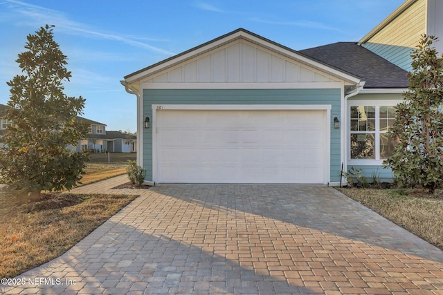 477 Cherry Elm Dr, Saint Augustine, FL 32092 - view of front of house with decorative driveway, board and batten siding, a garage, and a shingled roof