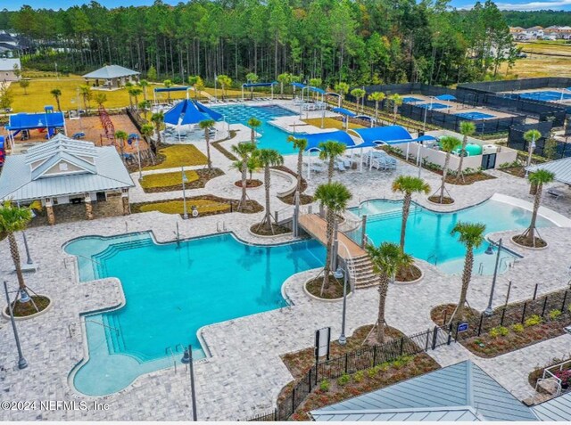 477 Cherry Elm Dr, Saint Augustine, FL 32092 - community pool featuring a water slide, fence, and a patio area