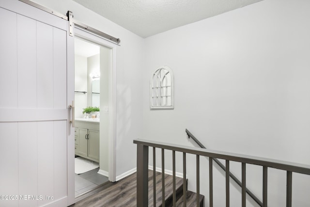303 Vista Lagoon Ct Unit C-3, Ponte Vedra Beach, FL 32082 - hallway featuring an upstairs landing, dark wood finished floors, a barn door, a textured ceiling, and baseboards