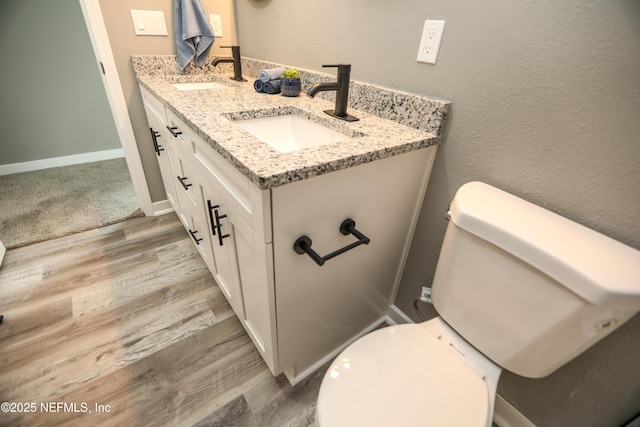 1207 Neva St, Jacksonville, FL 32205 - bathroom featuring wood finished floors, double vanity, toilet, and baseboards