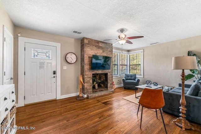 1724 Orlando Cir N, Jacksonville, FL 32207 - living room featuring a fireplace, wood finished floors, a textured ceiling, ceiling fan, and baseboards