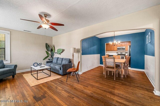 1724 Orlando Cir N, Jacksonville, FL 32207 - living room featuring a chandelier, arched walkways, dark wood-type flooring, a ceiling fan, and a textured ceiling