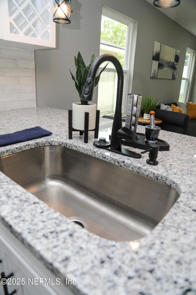1205 Neva St, Jacksonville, FL 32205 - kitchen view of a sink, light stone countertops, and white cabinetry