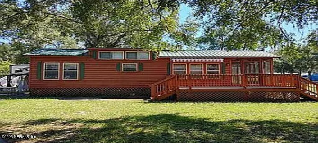 rear view of property featuring a lawn, a deck, and stairway