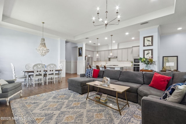 61 Sunrise Vista Way, Ponte Vedra, FL 32081 - living room featuring a chandelier, light wood-style flooring, a raised ceiling, wainscoting, and recessed lighting