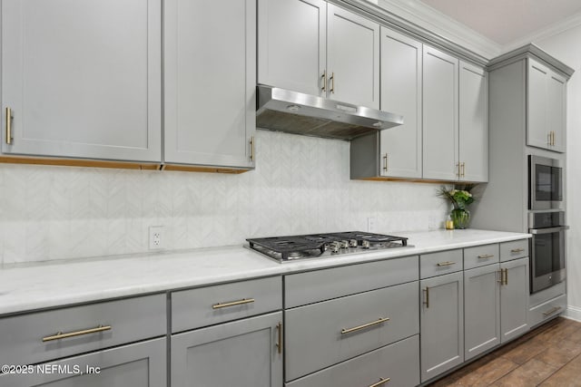 61 Sunrise Vista Way, Ponte Vedra, FL 32081 - kitchen featuring gray cabinets, under cabinet range hood, appliances with stainless steel finishes, ornamental molding, and backsplash