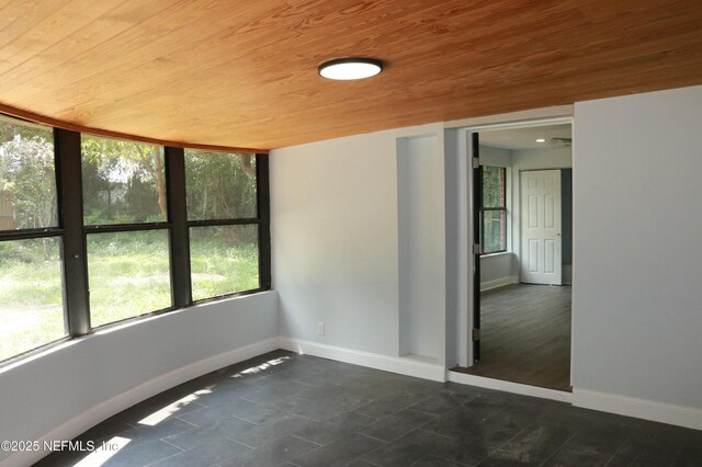 2242 Lake Lucina Dr, Jacksonville, FL 32211 - spare room with wooden ceiling, baseboards, and dark tile patterned flooring