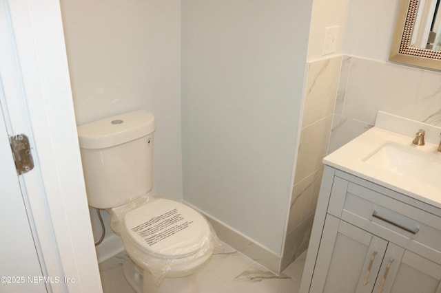 2242 Lake Lucina Dr, Jacksonville, FL 32211 - half bath featuring marble finish floors, vanity, toilet, and tile walls