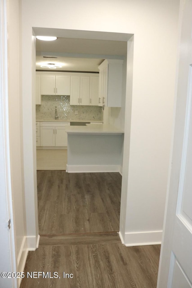 2242 Lake Lucina Dr, Jacksonville, FL 32211 - kitchen featuring dark wood-type flooring, white cabinets, light countertops, and baseboards