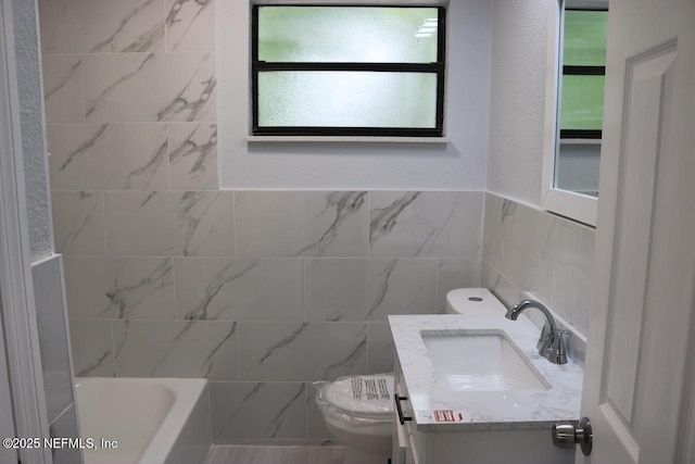 2242 Lake Lucina Dr, Jacksonville, FL 32211 - bathroom featuring toilet, tile walls, vanity, and bathing tub / shower combination