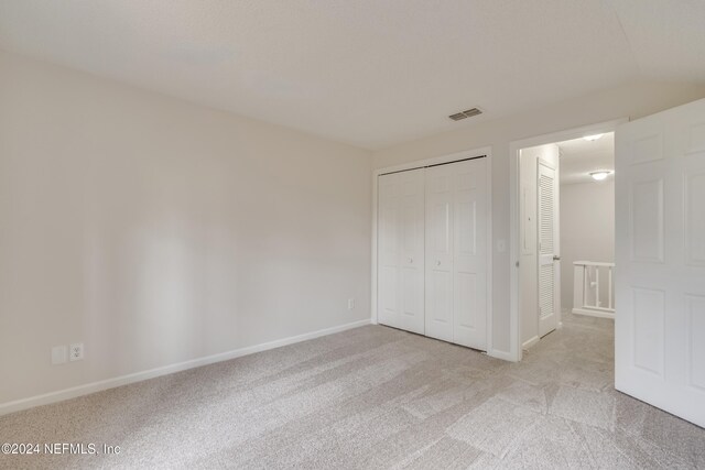 1701 Wood Hill Pl Unit 1701, Jacksonville, FL 32256 - unfurnished bedroom with light carpet, baseboards, and a closet