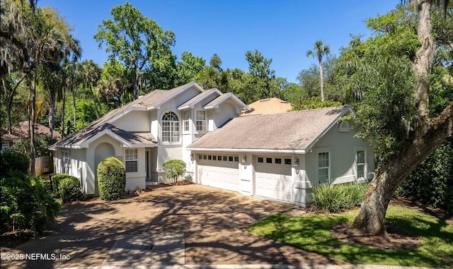 traditional home featuring stucco siding, driveway, and an attached garage