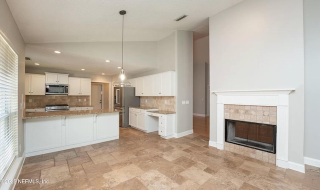 kitchen featuring appliances with stainless steel finishes, tasteful backsplash, light stone countertops, light stone finish floors, and white cabinets